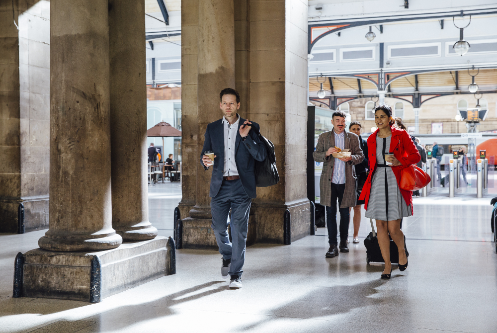 People leaving train station People carrying coffee leaving a train station