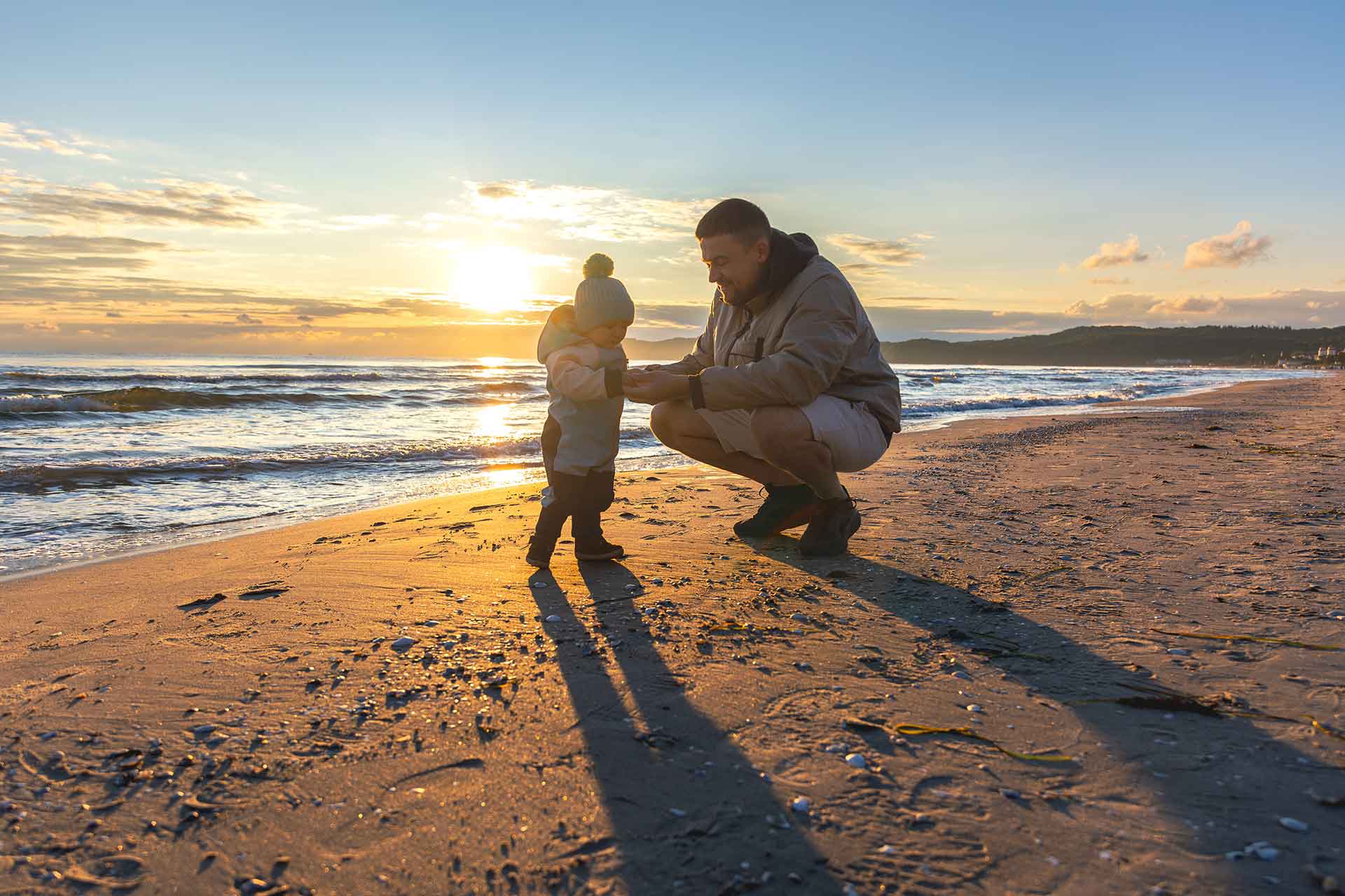 Green-Tourism-father-child-exploring-seashells-beach-sunset-toddler-with-dad-sand